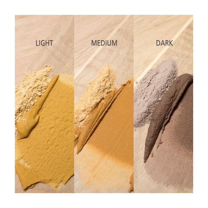 Three swatches of woodfiller powder labeled 'Light', 'Medium', and 'Dark' on a wooden surface.